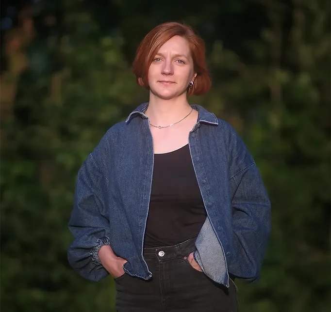 Andra Nuta smiling, in front of a leafy green background