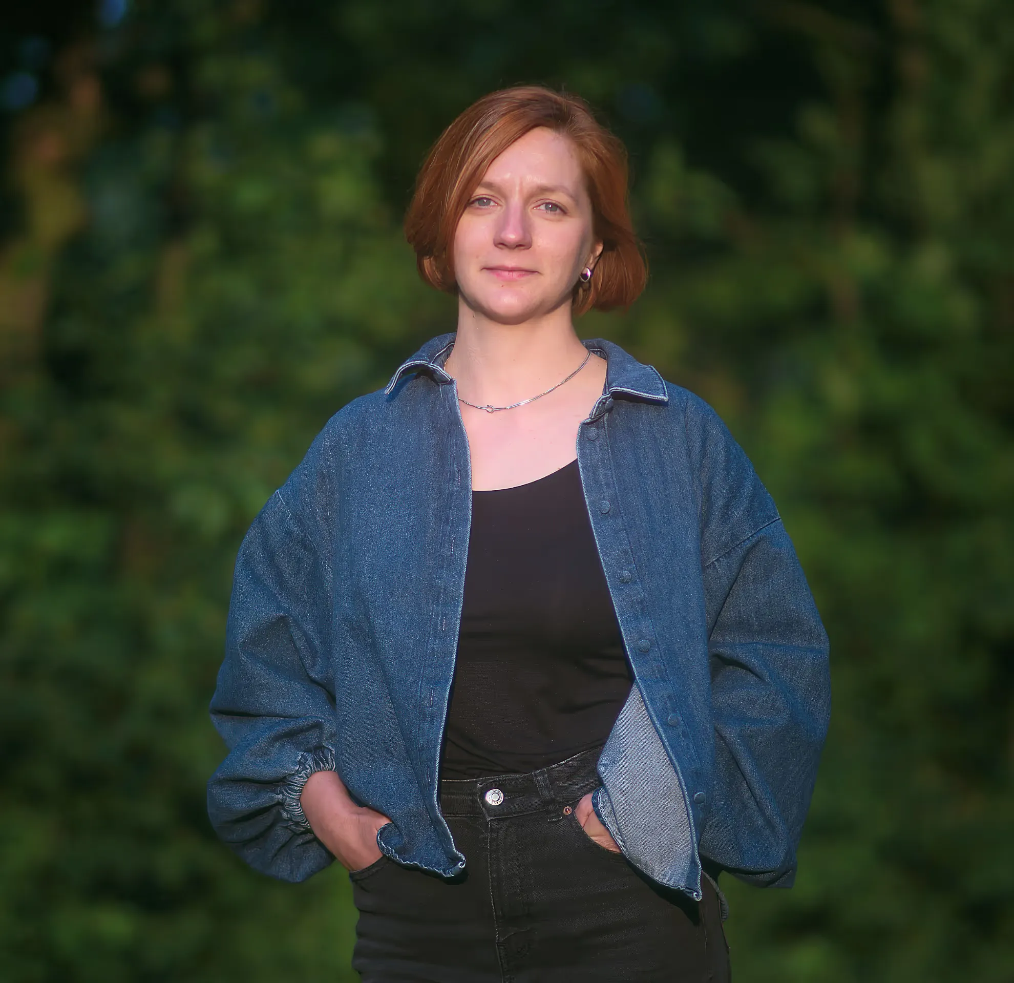 Andra Nuta smiling in front of a leafy green background